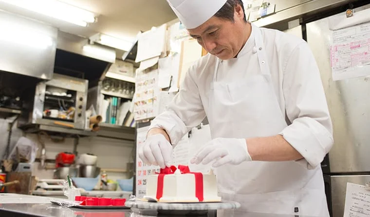 ケーキを仕上げるシェフ